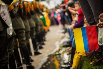 Mennesker i alle aldre i rolig demonstrasjon foran bevæpnede politi