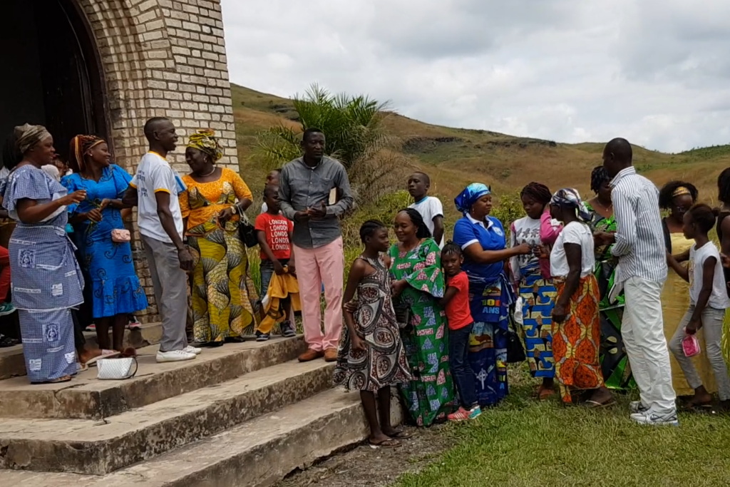 Kongoleserne hilser på hverandre utenfor kirken